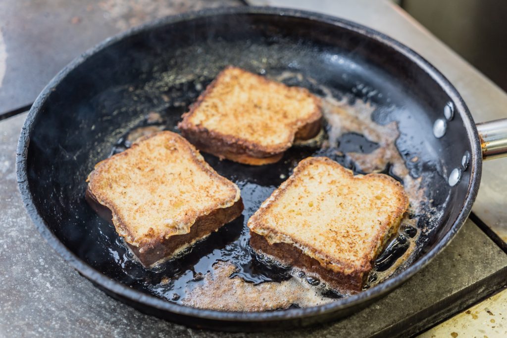 Altes Toastbroat wird in der Pfanne in Butter gebraten.