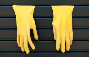 Gelbe Spülhandschuhe hängen an Rolläden.