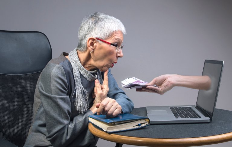 Ältere Frau sitzt am Computer.