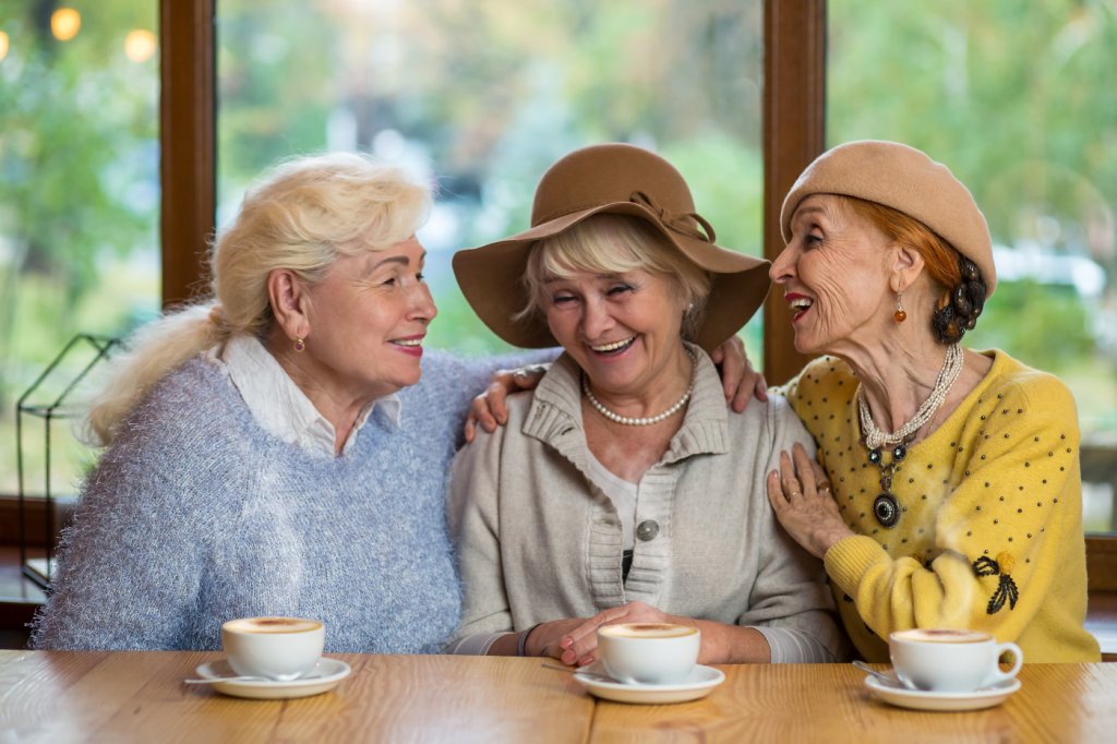 Drei Seniorinnen beim Kaffee an Theke