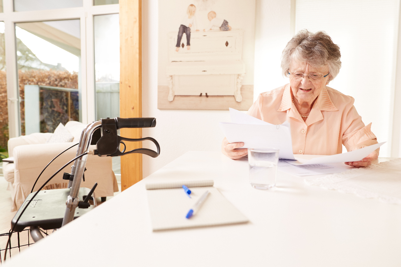 Seniorin blättert in Vertragsunterlagen des Pflegedienstleisters.