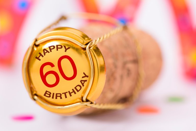 Ein Kronkkorken mit der Aufschrift 60. Geburtstag liegt auf dem Tisch.