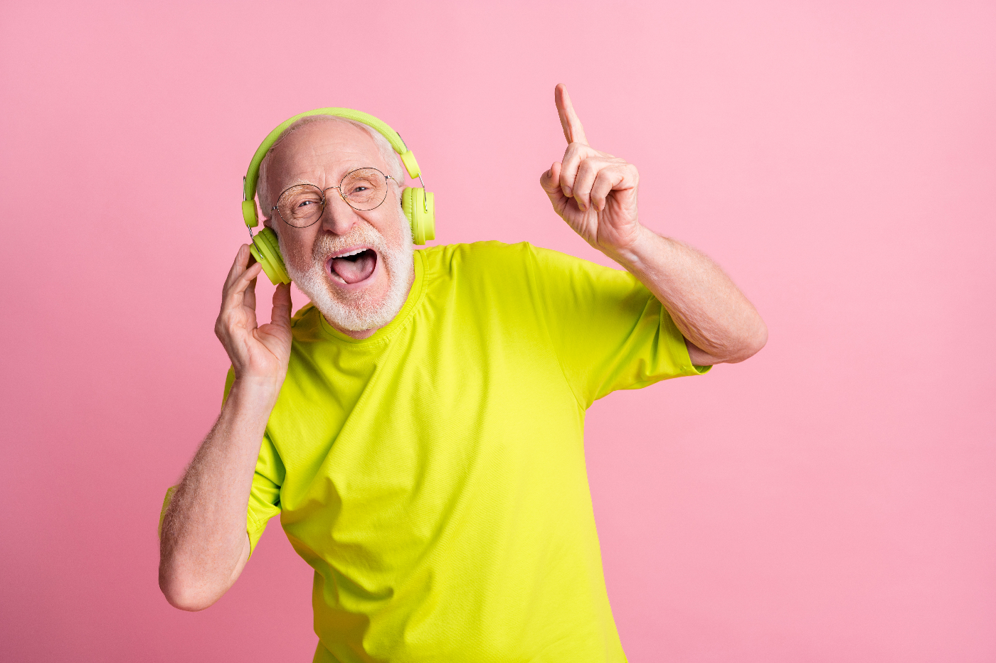 Senior hört mit Kopfhörern Musik und ist in guter Stimmung