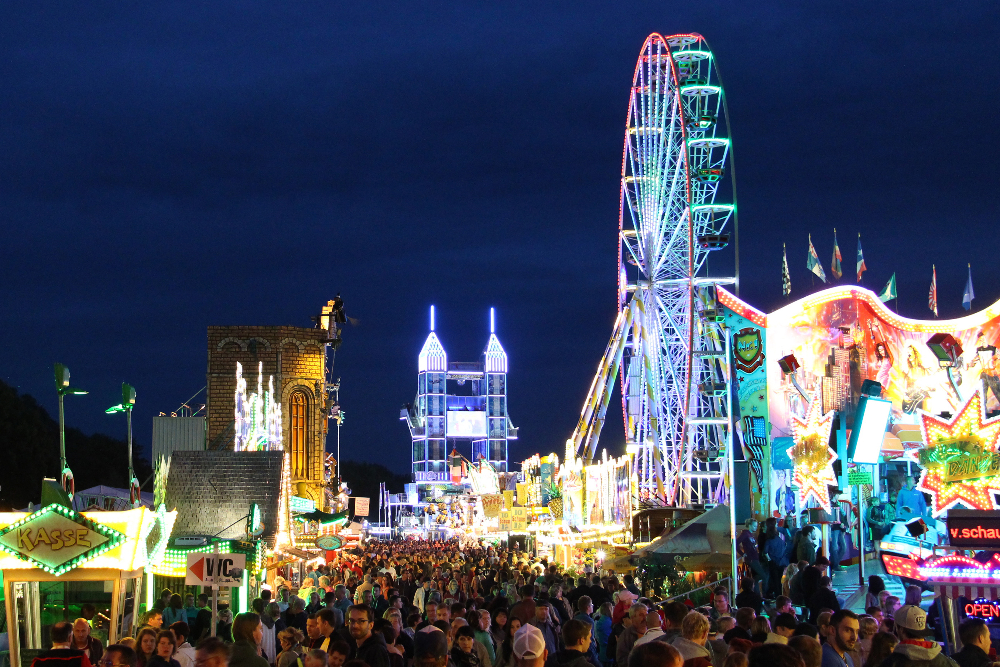 Das Altstadtfest in Rudolstadt in der Abenddämmerung mit Riesenrad und vielen Besuchern.