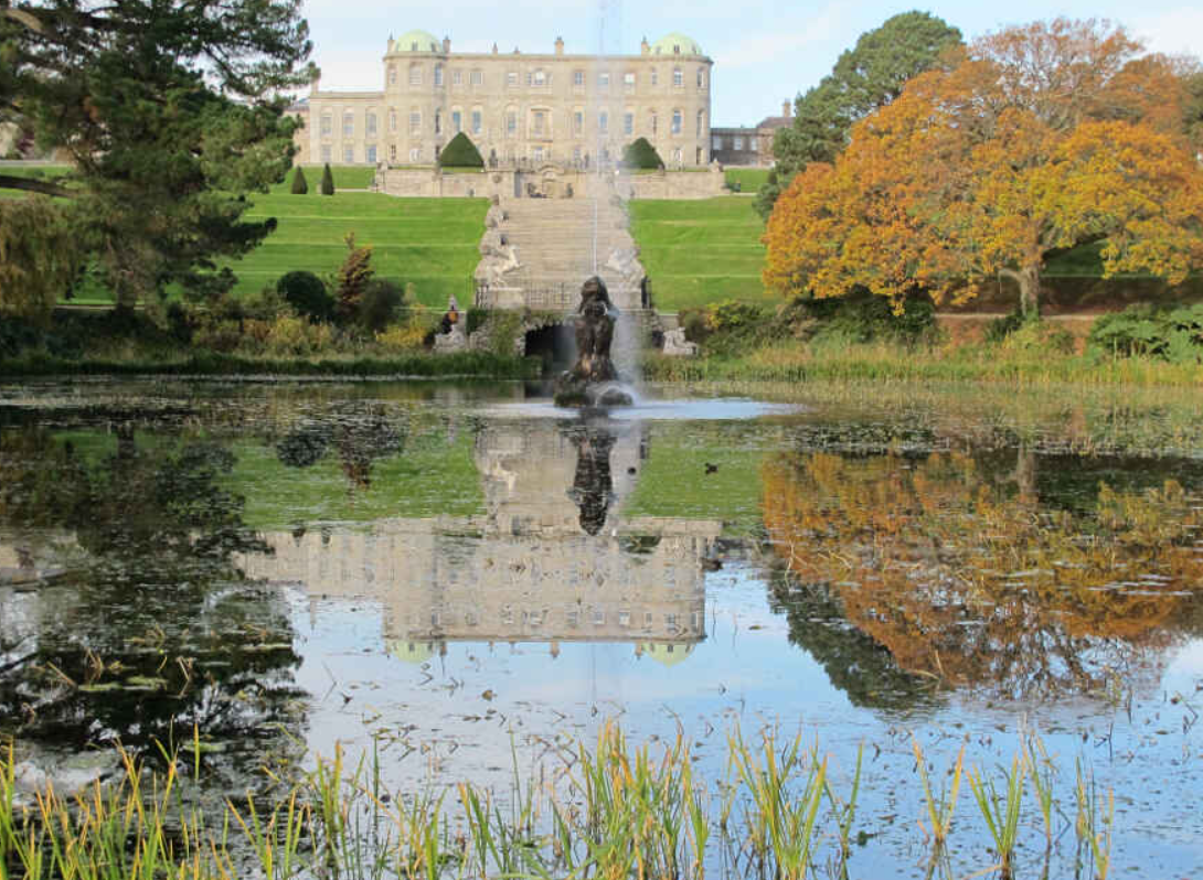 Garten von Schloss Powerscourt in Irland mit Spiegelung im See vor dem Schloss.