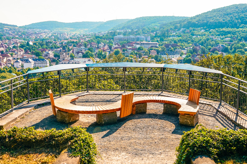 Die Aussichtsplattform am Altenberg auf Bad Kissingen mit einer geschwungenen Sitzbank lädt zum Verweilen ein.