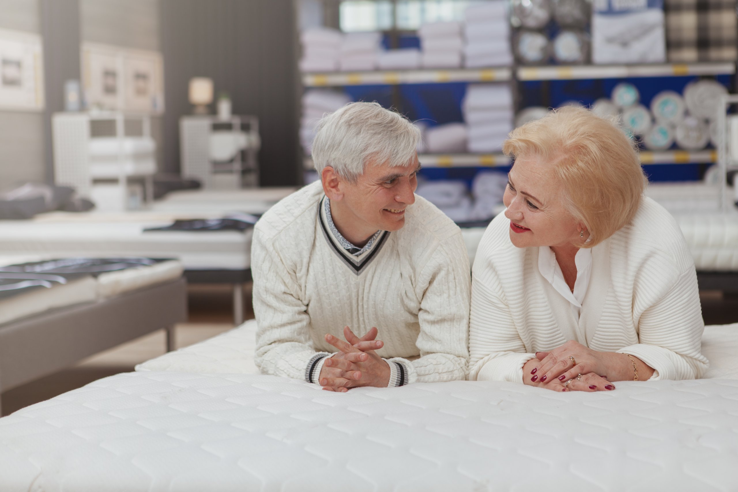 Zwei Senioren beraten über den Kauf einer Matratze.