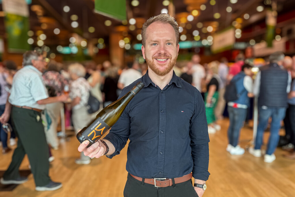 Winzer Karsten Lietz mit einer Scheurebe